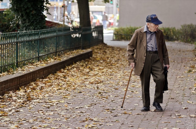 elderly man walking with cane